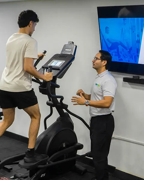 Paciente entrenando en elíptica con supervisión médica en MOVID