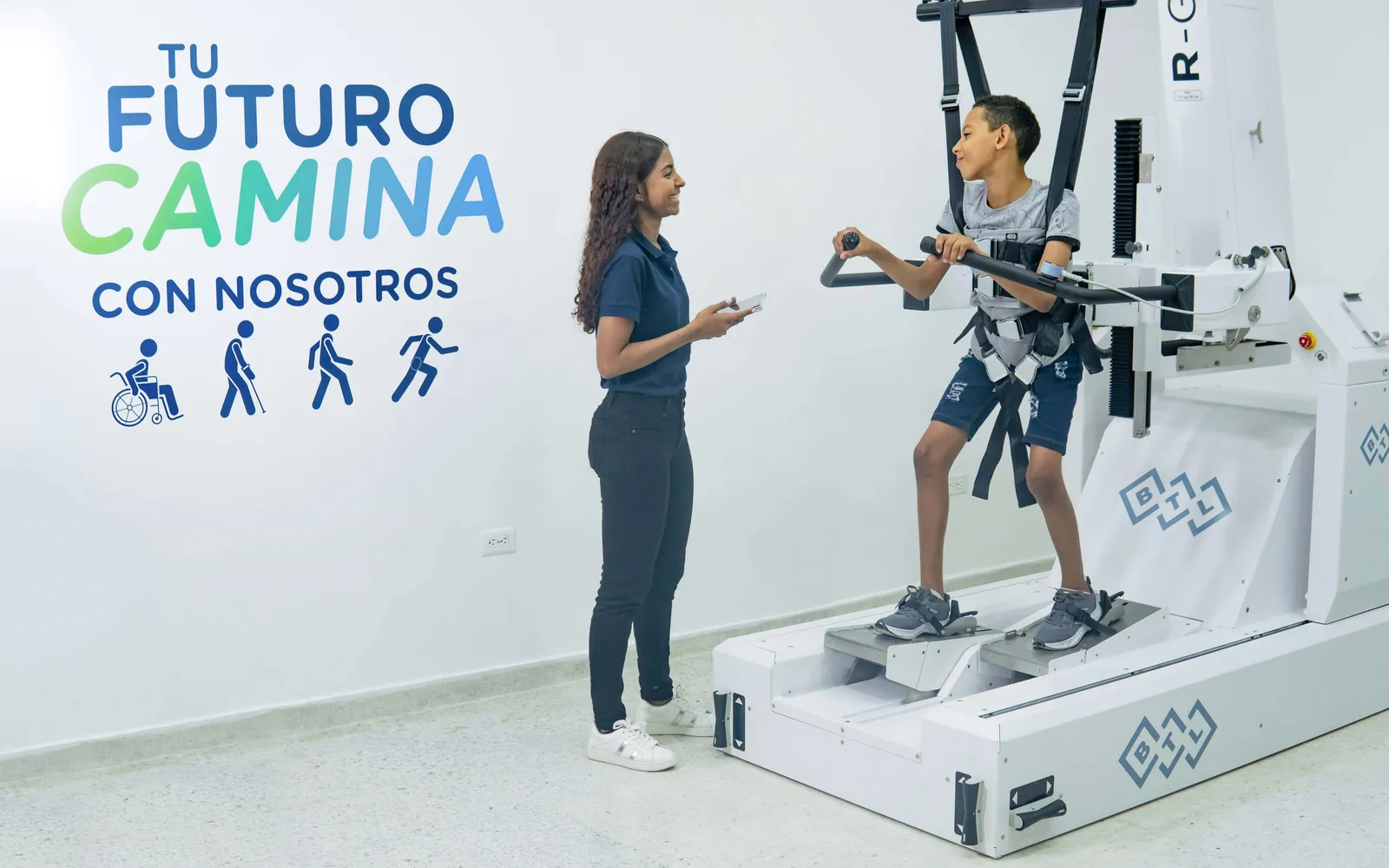 Paciente en terapia con el Robot R-Gait, acompañado por un terapeuta, en las instalaciones de MOVID en Barranquilla